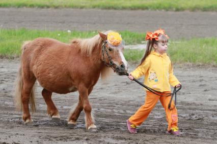Барнаул. Девочка ведет пони.