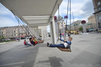 Москва. Мальчик качается на качелях на Триумфальной площади.