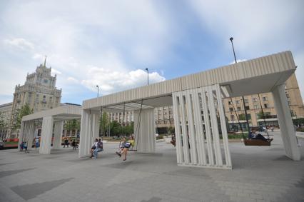 Москва. Горожане качаются на качелях на Триумфальной площади.