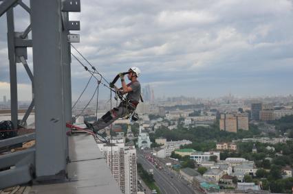 Москва.  Промышленный альпинист во время работы.