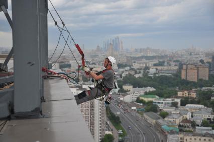 Москва.  Промышленный альпинист во время работы.