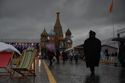 Москва. Прохожие  под зонтами на книжном фестивале `Красная площадь`.