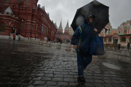 Москва. Мужчина под зонтом на Красной площади.