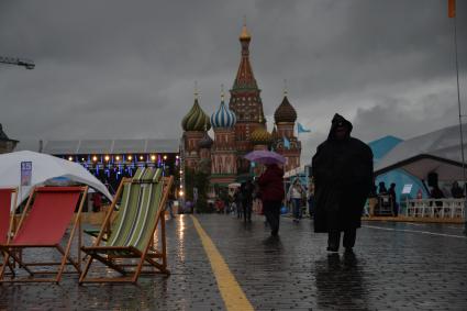 Москва. Прохожие  под зонтами на книжном фестивале `Красная площадь`.