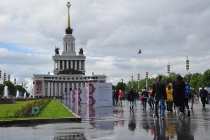 Москва.   Прохожие на   центральной аллее ВДНХ ,где открылась  фотовыставка  `Многонациональная Россия`.