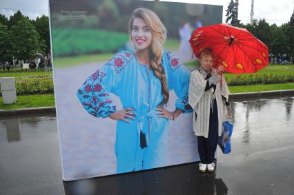 Москва.   Женщина под зонтом на   центральной аллее ВДНХ ,где открылась  фотовыставка  `Многонациональная Россия`.