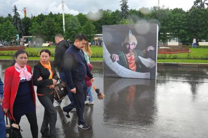 Москва.  Прохожие  на центральной аллее ВДНХ ,где открылась  фотовыставка  `Многонациональная Россия`.