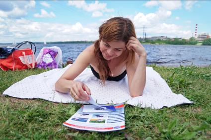 Екатеринбург. Девушка читает буклет о правилах поведения у воды, во время отдыха на городском пляже
