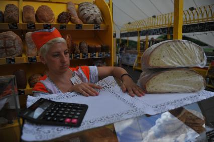 Москва. Продавец хлебобулочных изделий на ярмарке выходного дня на ВДНХ.