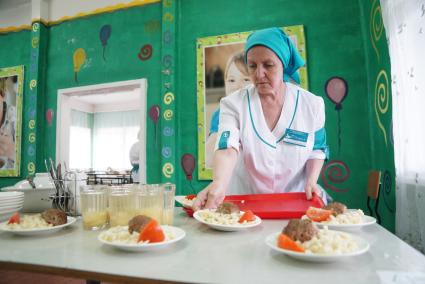 Свердловская область. Повар разносит обед в столовой детского летнего оздоровительного лагеря.