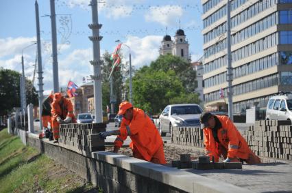 Белоруссия.  Минск. Рабочие укладывают  тротуарную плитку .