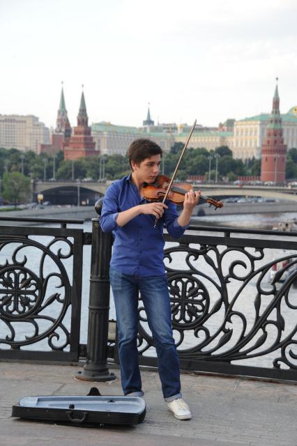 Москва.  Скрипач играет на Патриаршем мосту.