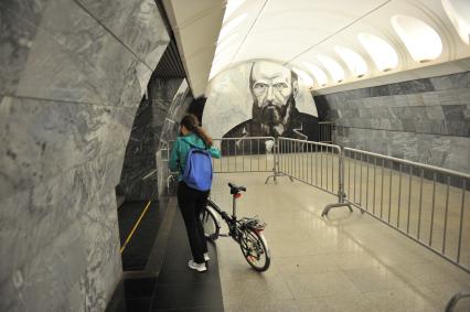 Москва. Девушка с велосипедом  на станции метро `Достоевская`.