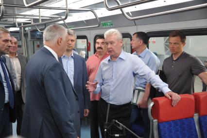 Москва.   Мэр Москвы Сергей Собянин (в центре) и  заместитель мэра Москвы по вопросам транспорта и развития дорожно-транспортной инфраструктуры Максим Ликсутов (справа) во время осмотра новых электропоездов, предназначенных для запуска по МКЖД, на Киевском вокзале.