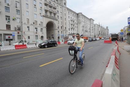 Москва.  Мужчина едет на велосипеде по Тверской улице,  которую вновь открыли после реконструкции.