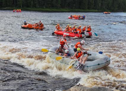 Республика Карелия.   Туристы на рафтах сплавляются по реке.