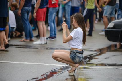 Ставрополь.Девушка фотографирует  на   Автовыставке \"Парковка\".
