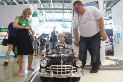 Екатеринбург. Ребенок в электромобиле на международной промышленной выставке \'Иннопром 2016\'