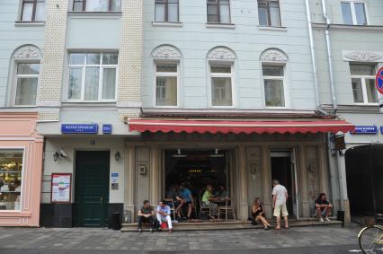 Москва.   Люди в кафе на улице Малая Бронная.