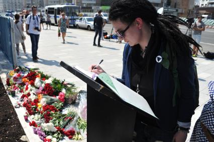Москва.  Прохожие возлагают цветы и свечи у посольства Франции в на Большой Якиманке в память о погибших в результате террористического акта в Ницце.