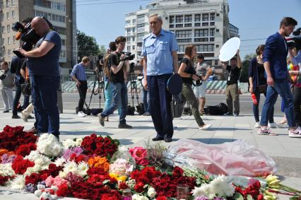 Москва.  Прохожие возлагают цветы и свечи у посольства Франции в на Большой Якиманке в память о погибших в результате террористического акта в Ницце.