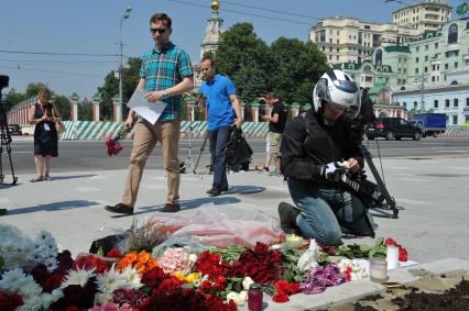 Москва.  Прохожие возлагают цветы и свечи у посольства Франции в на Большой Якиманке в память о погибших в результате террористического акта в Ницце.