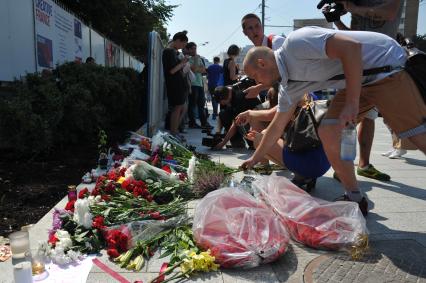 Москва.  Прохожие возлагают цветы и свечи у посольства Франции в на Большой Якиманке в память о погибших в результате террористического акта в Ницце.