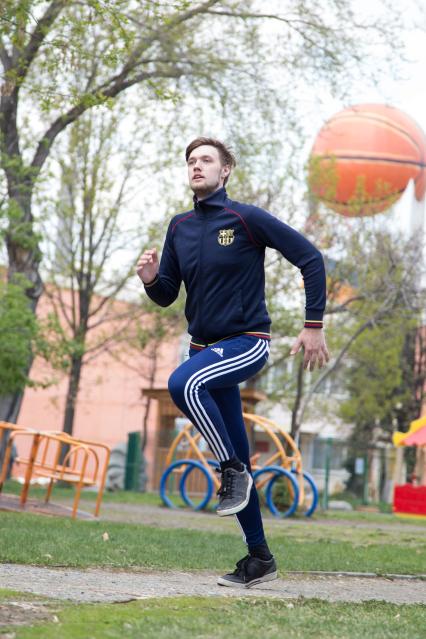 Челябинск. Молодой человек на разминке в парке.