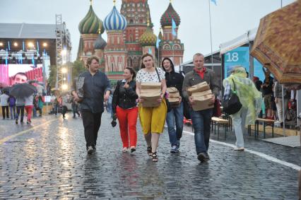 Москва. Посетители  во время дождя на книжном фестивале `Красная площадь`.