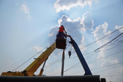 Екатеринбург. Рабочие в люльке подъемника, перед демонтажем опоры ЛЭП на месте реконструкции улично-дорожной сети у Центрального стадиона, к Чемпионату мира по футболу 2018