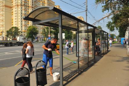 Москва. Сотрудники коммунальных служб моют остановку общественного транспорта возле метро `Университет`.