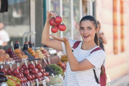 Челябинск. Девушка выбирает помидоры на рынке.