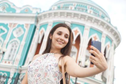 Екатеринбург. Девушка фотографируется на фоне дома Севастьянова - достопримечательность города, где размещается резиденция губернатора Свердловской области. Внесен в список на голозование за символ города, для размещения на новых банкнотах 200 и 2000 рублей