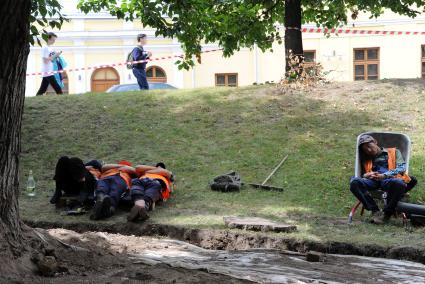 Москва.   Рабочие спят на газоне во время обеденного перерыва.