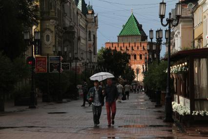 Нижний Новгород.  Мужчины идут под одним зонтом.