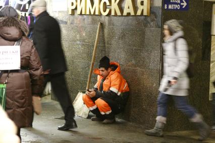 Москва. Дворник  сидит в переходе станции метро `Римская`.