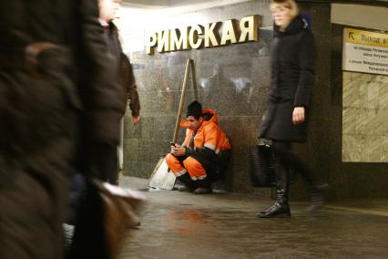 Москва. Дворник  сидит в переходе станции метро `Римская`.