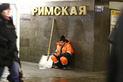 Москва. Дворник сидит в переходе станции метро `Римская`.