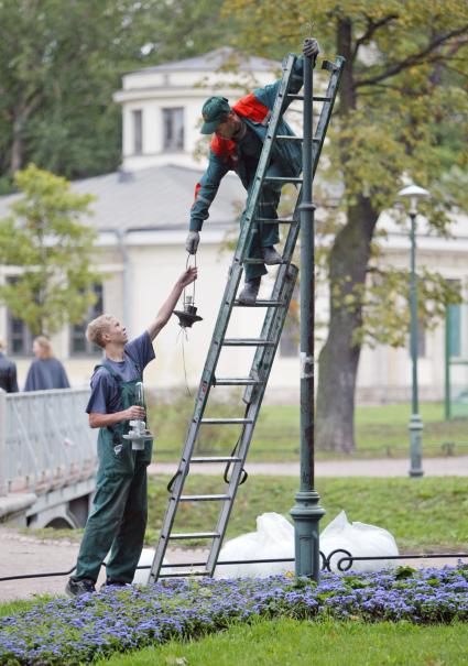 Санкт-Петербург. Рабочие ремонтируют уличный фонарь.