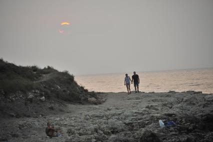 Крым. Херсонес. Отдыхающие гуляют на берегу моря.