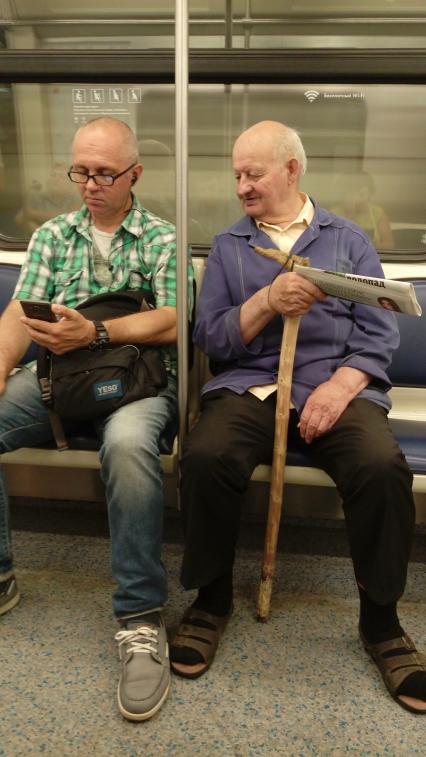 Москва. Мужчины за чтением новостей в метро.