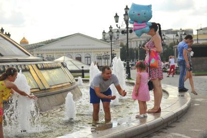 Москва. Дети купаются в фонтане на Манежной площади.