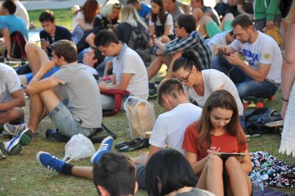 Москва. Молодые люди играют в Pokemon Go от компании Nintendo в Ильинском сквере.