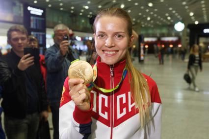 Санкт-Петербург. Российская спортсменка Екатерина Дьяченко, завоевавшая золотую медаль в командном турнире по фехтованию на саблях среди женщин на XXXI летних Олимпийских играх, во время встречи в аэропорту `Пулково`.