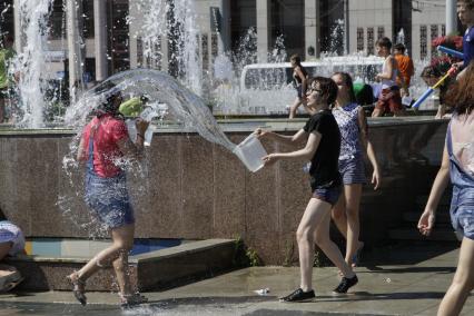 Казань. Молодые люди  обливают друг друга  водой из фонтана.