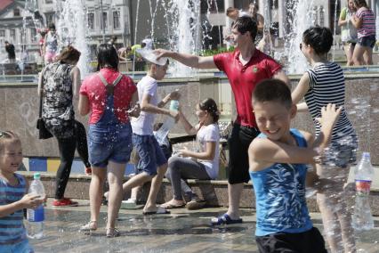 Казань. Молодые люди  обливают друг друга  водой из фонтана.