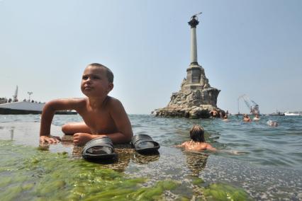 Крым, Севастополь. Отдыхающие купаются у памятника затопленным кораблям.