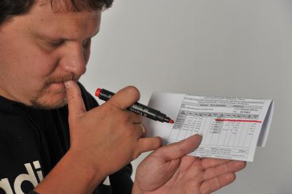 Москва. Корреспондент `Комсомольской правды` Олег Адамович держит в руках квитанцию на оплату коммунальных услуг.