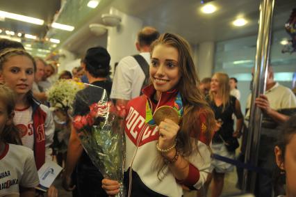 Москва. Вера Бирюкова, завоевавшая золотую медаль в групповых соревнованиях по художественной гимнастике , во время церемонии встречи чемпионов и призеров ХХХI летних Олимпийских игр Рио 2016 в аэропорту `Шереметьево`.