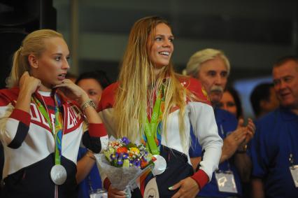 Москва. Яна Кудрявцева завоевавшая серебрянную медаль по художественной гимнастике и Юлия Ефимова  (справа) завоевавшая серебряную медаль по плаванию , во время церемонии встречи чемпионов и призеров ХХХI  летних Олимпийских игр  Рио 2016  в аэропорту `Шереметьево`.